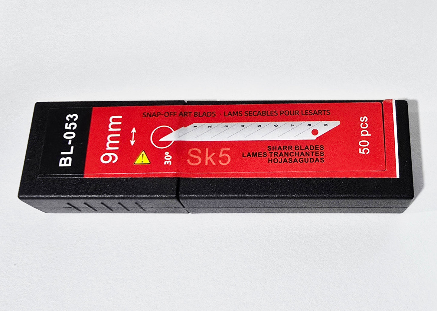 A pack of 50 sharp snap-off art blades for knives, featuring a black plastic case with a red label. The label displays '9mm', 'Sk5', '50 pcs', and 'Snapping-Off Art Blades' in white and yellow text, with a graphic of a knife blade.